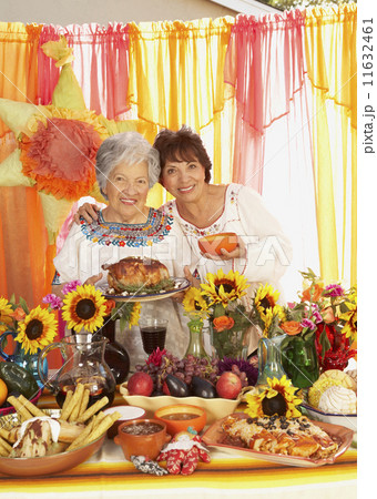 Hispanic woman and adult daughter behind buffet table 11632461