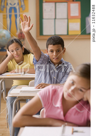 Student raising his hand in class Student raising his hand in class 11632488