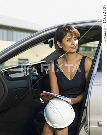 Indian woman holding hard hat in car Indian woman holding hard hat in car 11632507