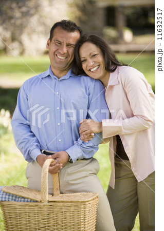 Hispanic couple holding picnic basket 11632517