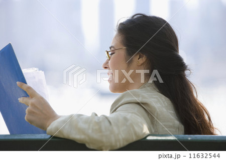 Profile of businesswoman reading papers Profile of businesswoman reading papers 11632544