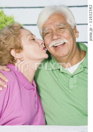 Senior Hispanic woman kissing husband's cheek Senior Hispanic woman kissing husband's cheek 11632562