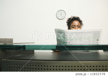 Businesswoman reading newspaper 11632576