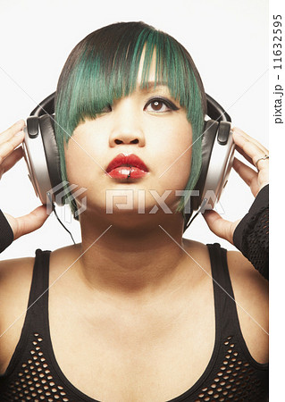 Asian woman listening to headphones Asian woman listening to headphones 11632595