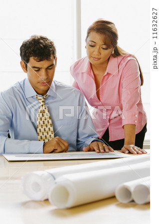 Multi-ethnic businesspeople looking at blueprints 11632627