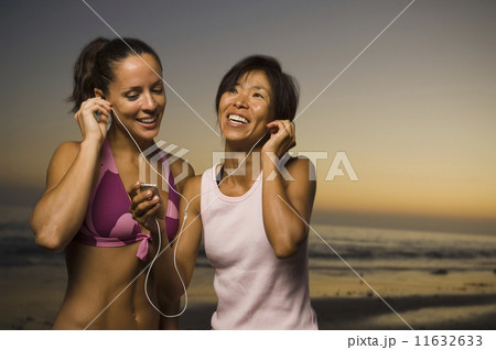 Multi-ethnic friends listening to same mp3 player Multi-ethnic friends listening to same mp3 player 11632633