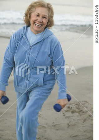 Senior woman with weights at the beach Senior woman with weights at the beach 11632666