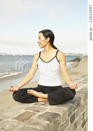 Asian woman meditating on wall 11632667