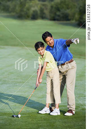 Hispanic father helping daughter play golf 11632716