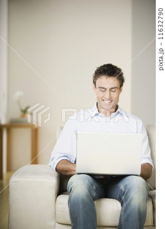 Man using laptop on sofa Man using laptop on sofa 11632790