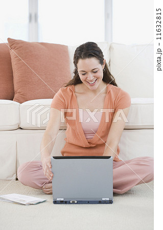 Hispanic woman sitting on floor using laptop Hispanic woman sitting on floor using laptop 11632815