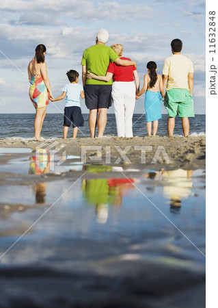 Rear view of family holding hands at beach 11632848