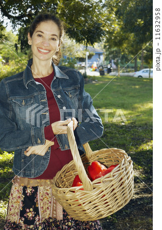 Middle Eastern woman carrying basket of organic produce Middle Eastern woman carrying basket of organic produce 11632958