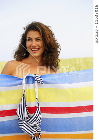 Woman changing behind screen in field 11633016