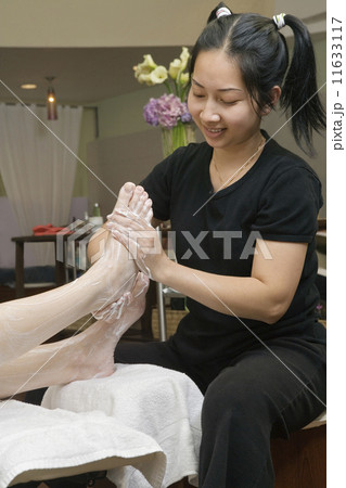 Asian spa technician giving massage Asian spa technician giving massage 11633117