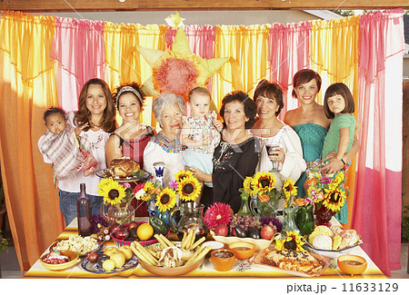 Multi-ethnic Mixed Race female family members behind buffet table 11633129