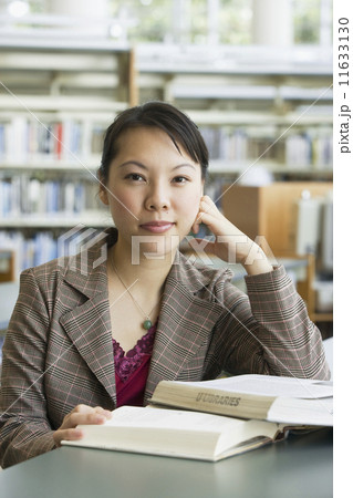 Asian woman with books in library Asian woman with books in library 11633130