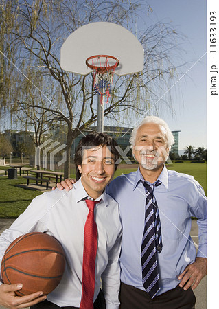 Two Hispanic businessmen on a basketball court  11633193