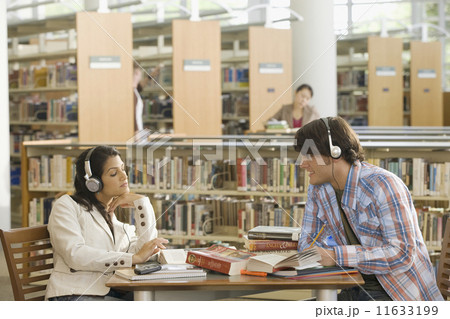 Multi-ethnic couple studying in library Multi-ethnic couple studying in library 11633199