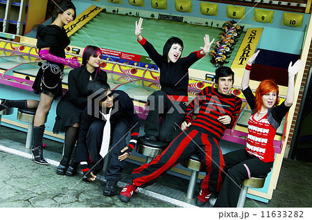 Group of punk Hispanic teenagers cheering in carnival booth Group of punk Hispanic teenagers cheering in carnival booth 11633282