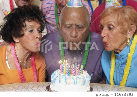Senior Mixed Race man blowing out birthday candles 11633292
