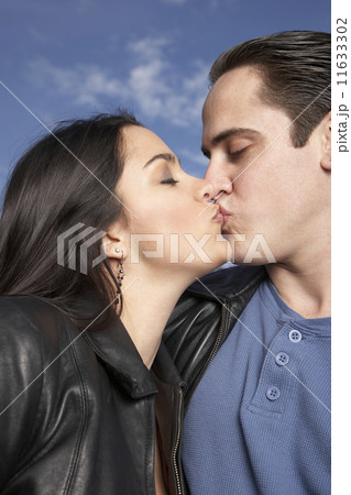 Multi-ethnic couple kissing outdoors Multi-ethnic couple kissing outdoors 11633302