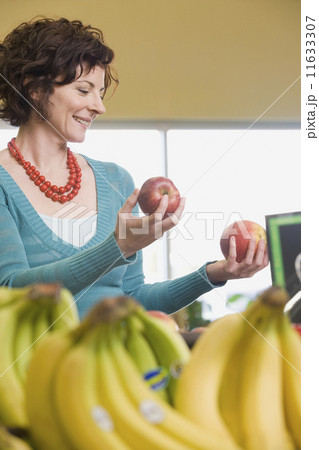 Woman choosing apples at grocery store Woman choosing apples at grocery store 11633307