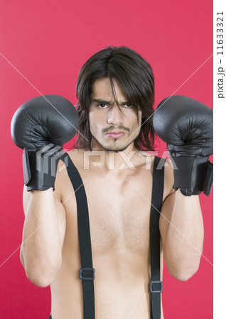 Young Hispanic man wearing boxing gloves 11633321