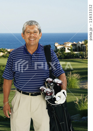 Hispanic man holding bag of golf clubs Hispanic man holding bag of golf clubs 11633332