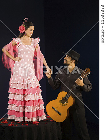 Hispanic female flamenco dancer smiling at guitar player Hispanic female flamenco dancer smiling at guitar player 11633333
