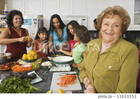 Large Hispanic family in kitchen preparing food 11633353