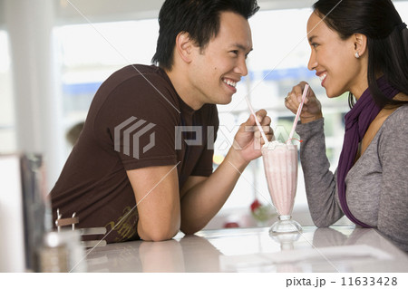 Asian couple sharing milkshake 11633428