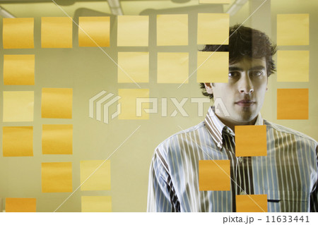 Businessman standing behind decorative glass 11633441