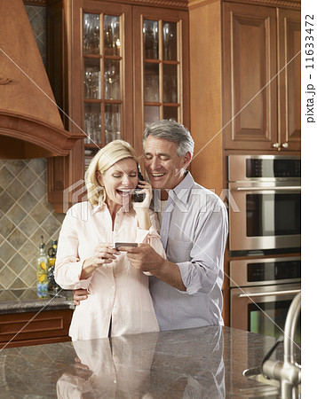 Multi-ethnic couple shopping on telephone 11633472