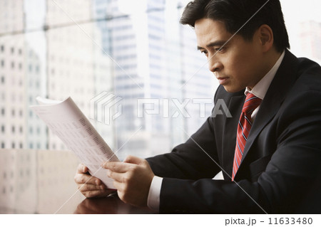 Chinese businessman reading report Chinese businessman reading report 11633480