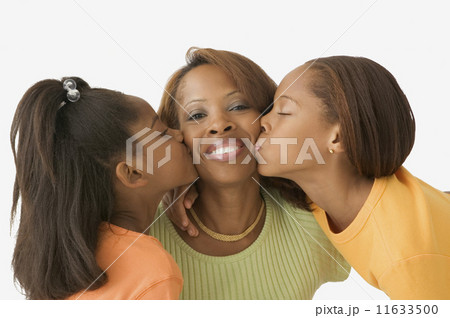 Daughters kissing their mothers' cheeks 11633500