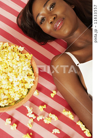 African woman laying next to popcorn bowl African woman laying next to popcorn bowl 11633557