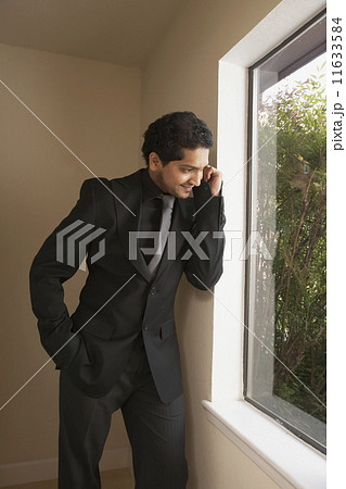 Indian businessman looking out window 11633584