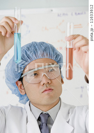 Asian male scientist comparing vials 11633612