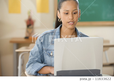 Female Dominican teenager working on a laptop in a classroom Female Dominican teenager working on a laptop in a classroom 11633622