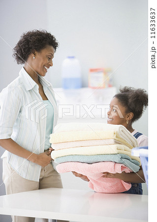 African American mother and daughter doing laundry 11633637