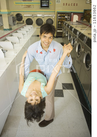 Couple dancing in a laundromat Couple dancing in a laundromat 11633662