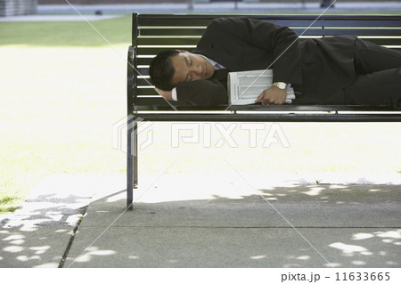 Asian businessman sleeping on park bench Asian businessman sleeping on park bench 11633665