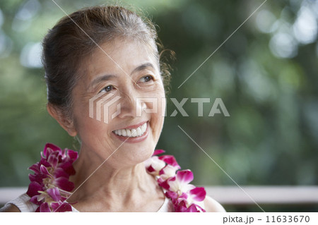 Senior Asian woman wearing lei 11633670