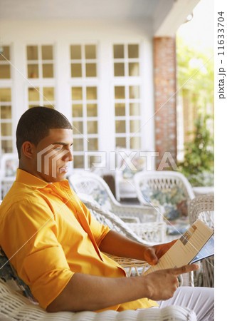 Hispanic man reading magazine 11633704