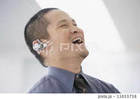 Asian businessman talking on hands-free device 11633738