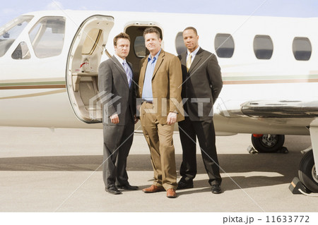 Multi-ethnic businessmen in front of airplane 11633772