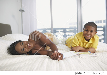 African American mother and son laying on bed 11633787