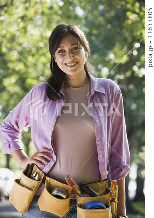 Hispanic woman wearing tool belt Hispanic woman wearing tool belt 11633805