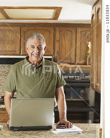Senior Hispanic man paying bills Senior Hispanic man paying bills 11633834